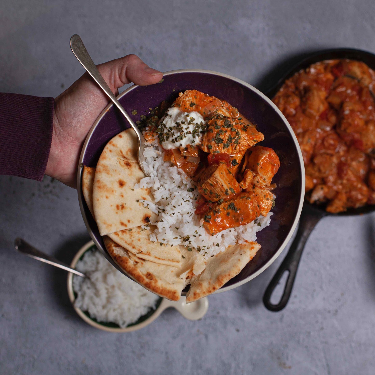 Bowl of chicken curry, rice and flatbread