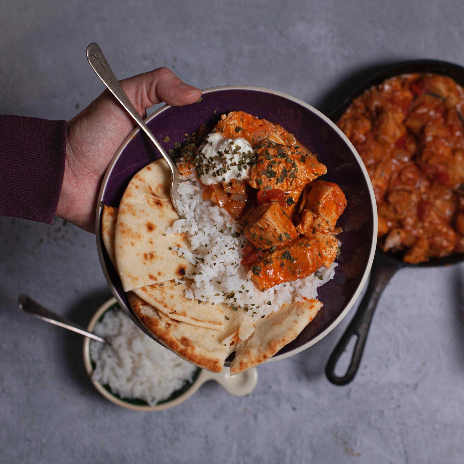 Bowl of chicken curry, rice and flatbread